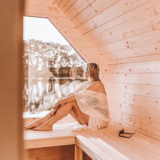 kobieta korzystająca z sauny z widokiem na jezioro
