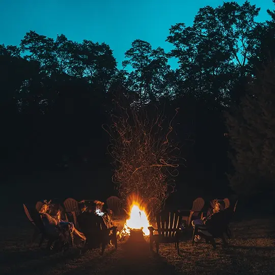 grupa ludzi spędzająca czas przy ognisku wieczorem