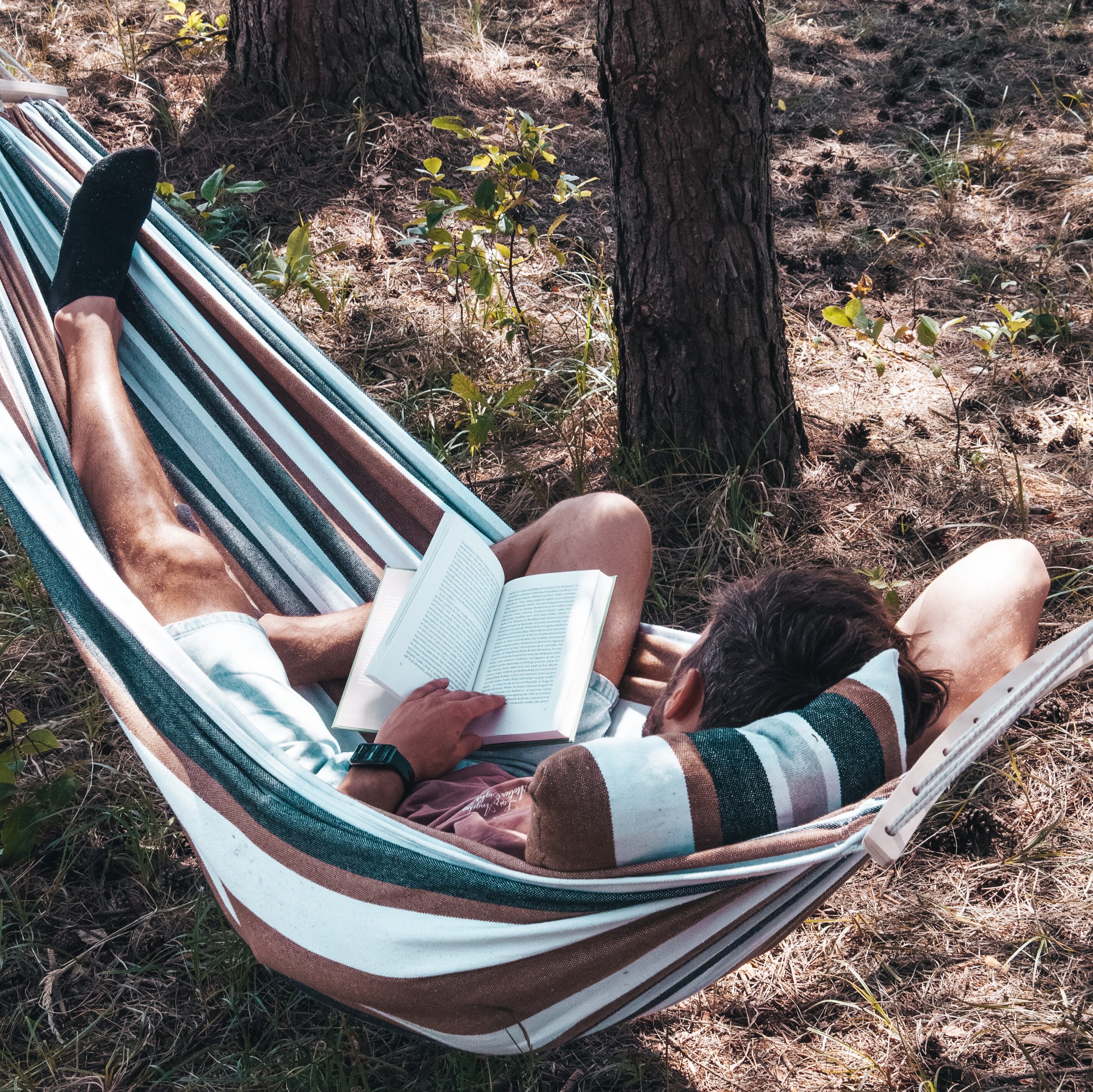 Mężczyzna czytający książkę w hamaku